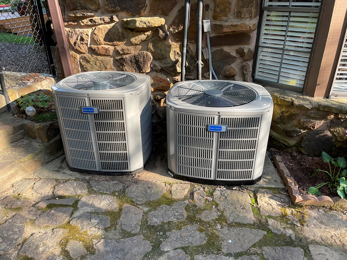 Two American Standard residential air conditioning units installed at a home.